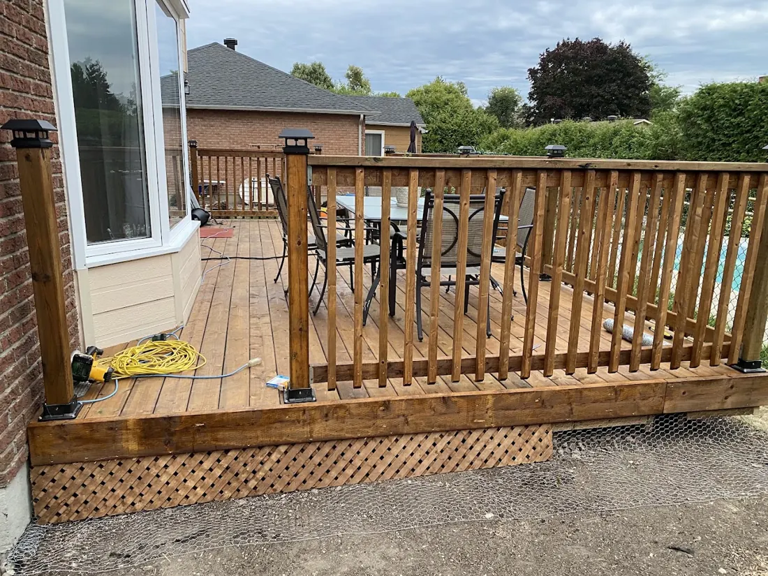 Wooden deck with railing attached to a brick home