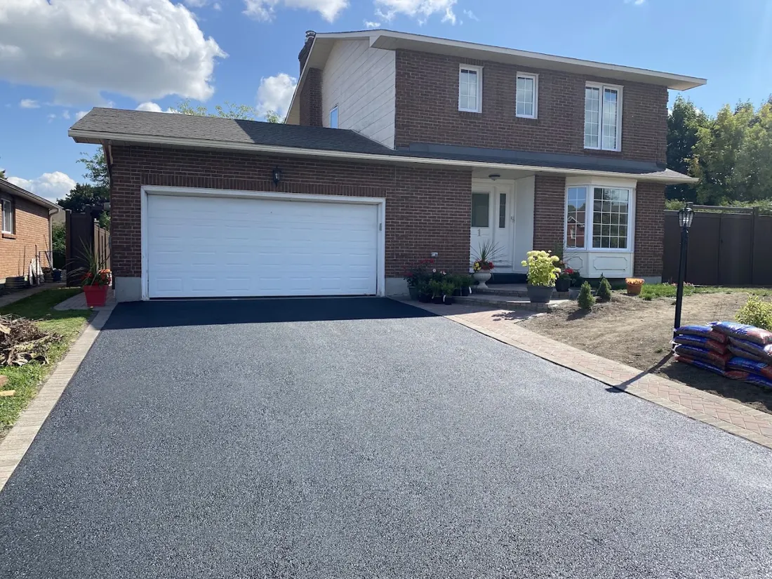 Brick house with a new asphalt driveway and landscaped front yard